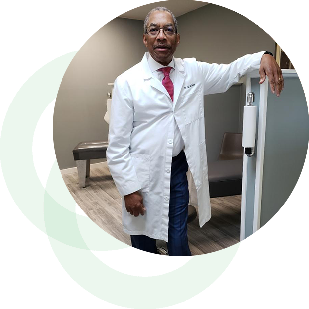 A man in white lab coat standing next to a refrigerator.